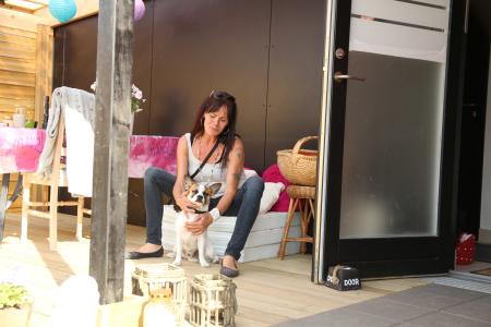 Kvinde sidder med hun på overdækket terrasse